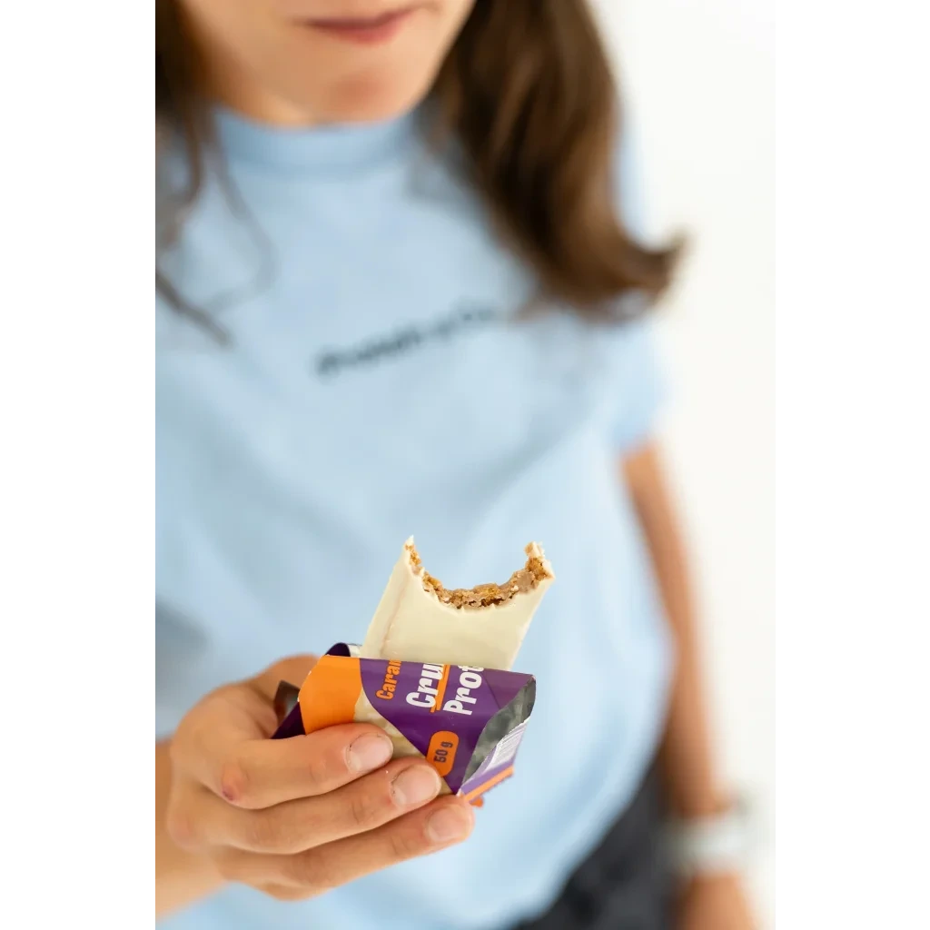 Crunchy proteinová tyčinka karamel v ruce